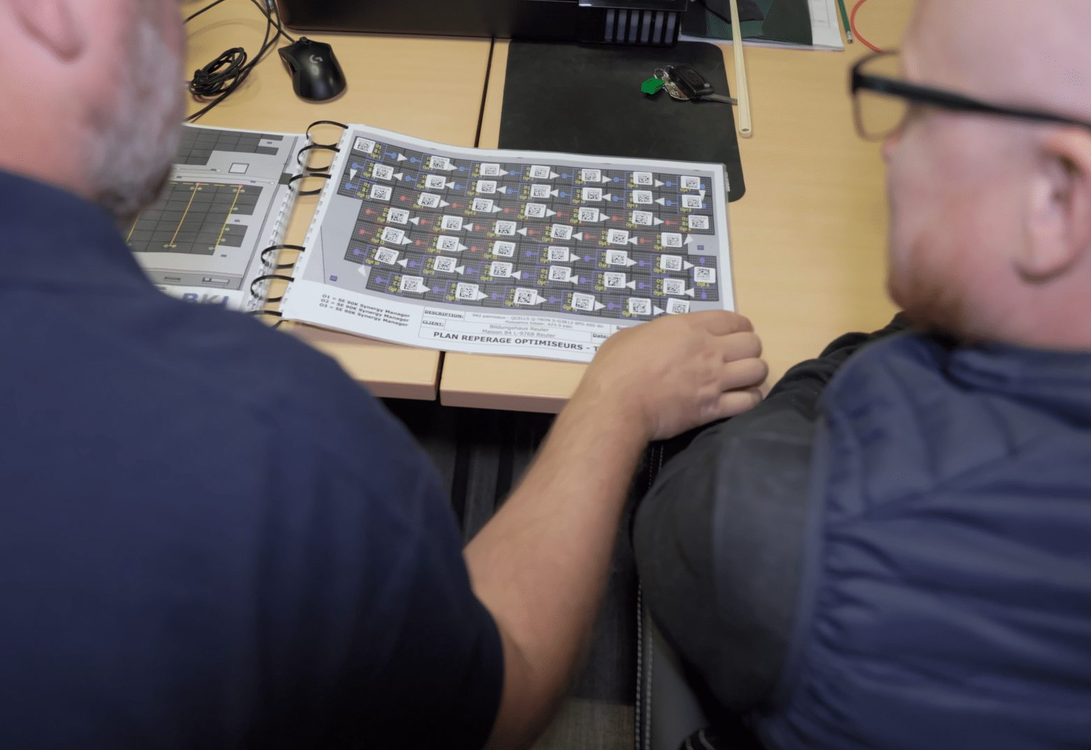 Deux homme regardent un plan de repérage